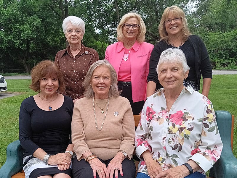 Womans-Club-of-York-2026-27-Officers Six women outdoors in a park, three seated in front and three standing behind, smiling for the photo.